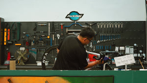 BikeCraft.One mechanic servicing a road bike at the Park Tool workbench