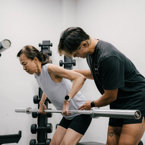 A coach cueing a barbell hinge at STR Fitness Club