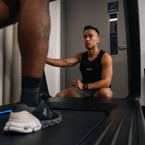 A runner on the treadmill with an STR coach watching their stride