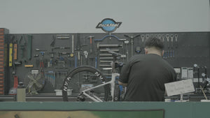 Mechanic servicing a road bike at the BikeCraft.One Park Tool bench