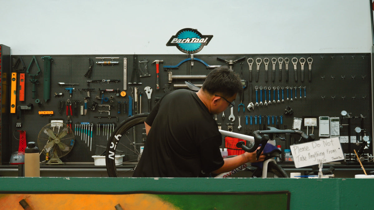 BikeCraft.One mechanic servicing a road bike at the Park Tool workbench